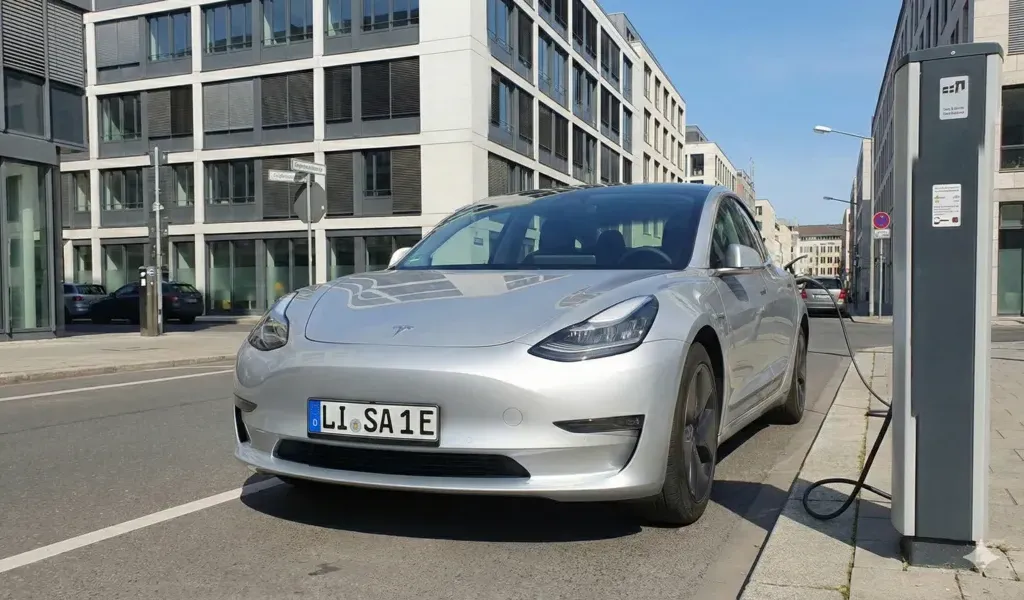 Elektroauto lädt an einer Ladesäule mit E-Kennzeichen